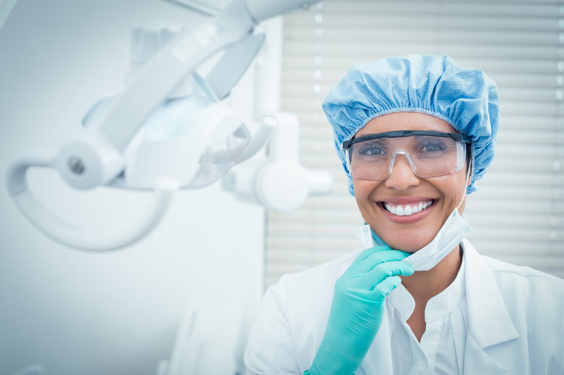 female-dentist-wearing-surgical-cap-and-safety-glasses